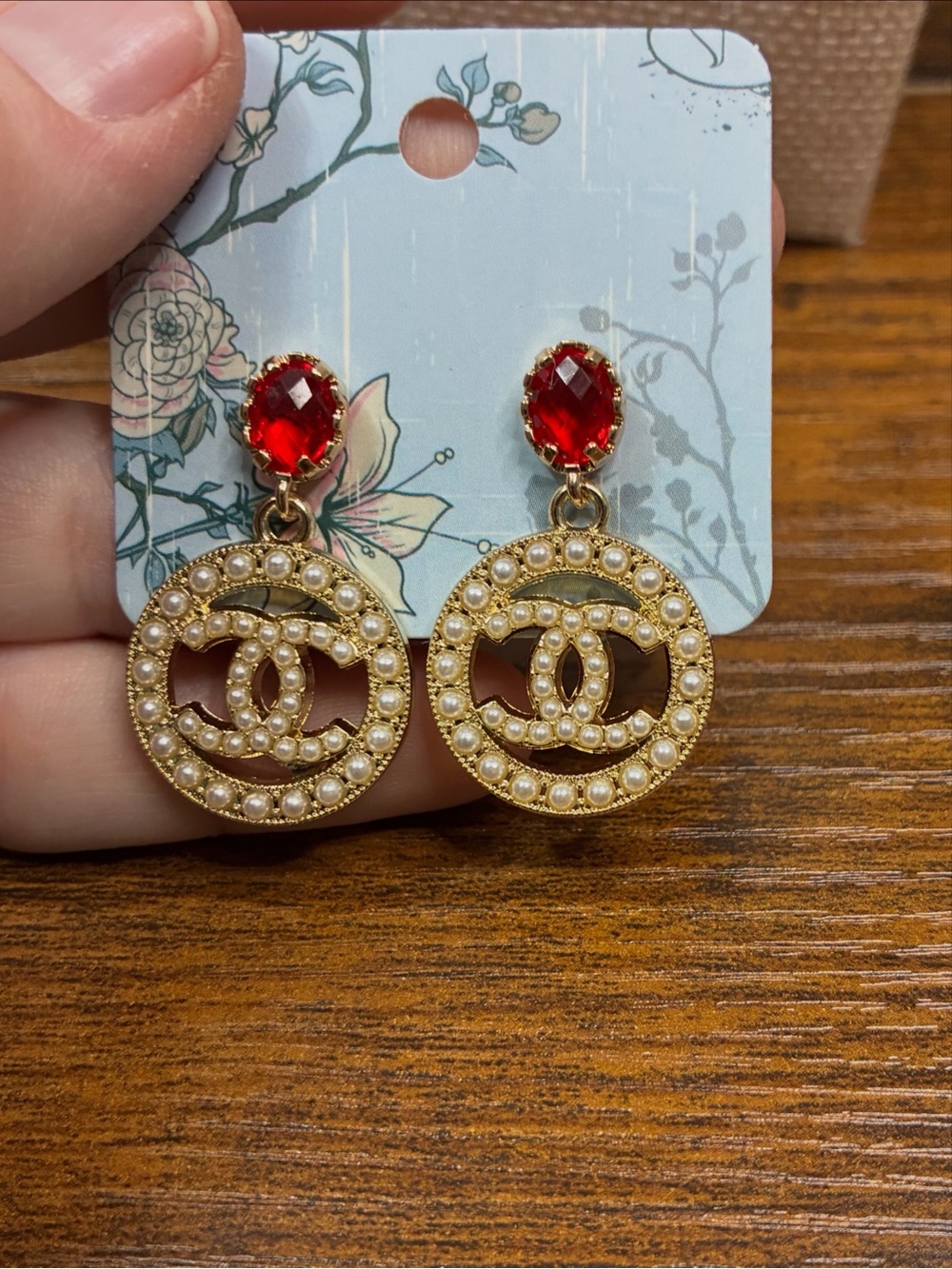 Gold Pearl Logo Drop Earrings with Red Crystal Accent